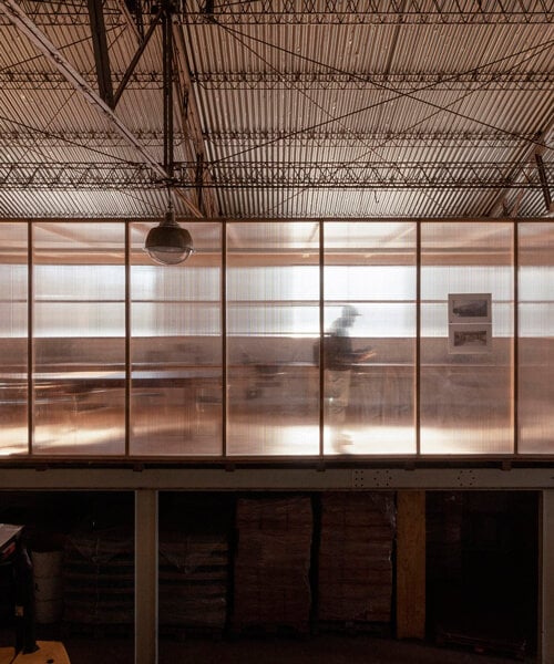polycarbonate panels reflect light within minimalist atelier industrial in argentina